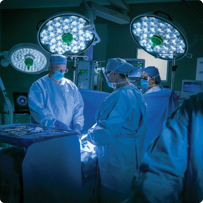 tgh and usf health physicians performing surgery on a patient in a dark operating room at tgh, part of tampa medical and research district